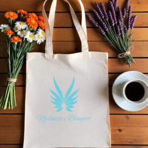 Bež platnena vrećica s tiskanim dizajnom leži na drvenoj podlozi. Na vrećici je plavi simbol stiliziranih anđeoskih krila, ispod kojeg je ispisan tekst Nježnost i Blagost u elegantnom rukopisnom fontu.